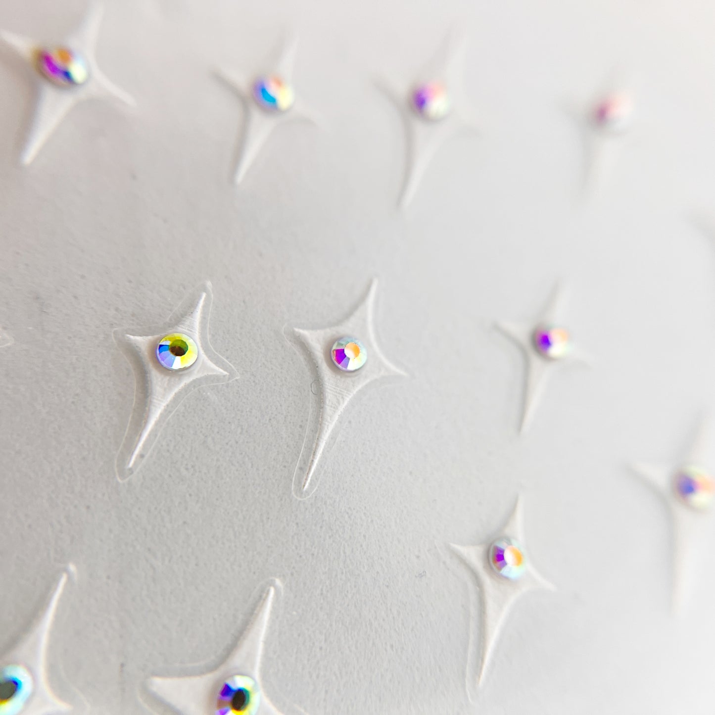 Jewel Star Nail Stickers - Four-Point Stars with Center Rhinestone Detail, pictured in White with iridescent rhinestone. 