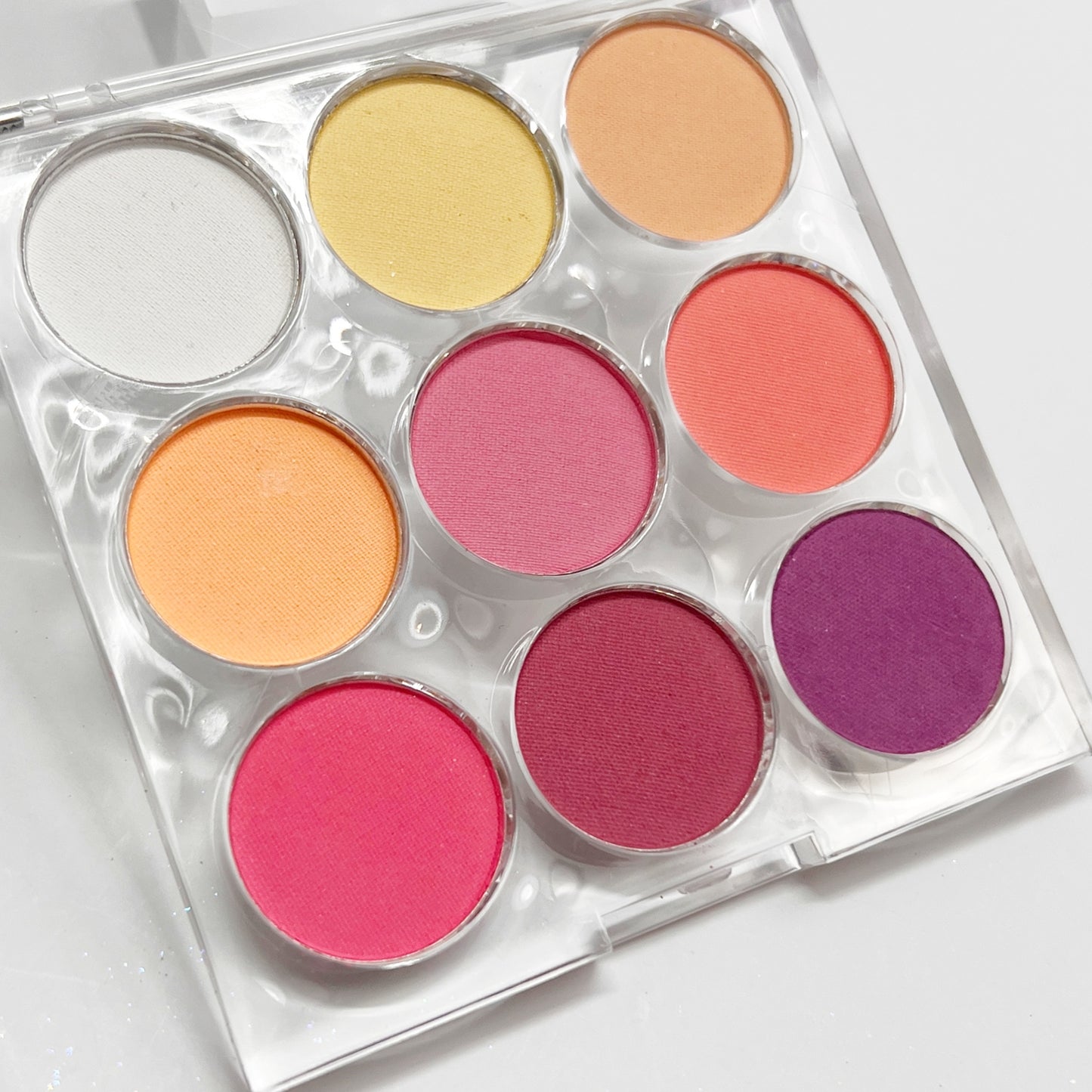 Multicolor pigment palette in clear case on white background.