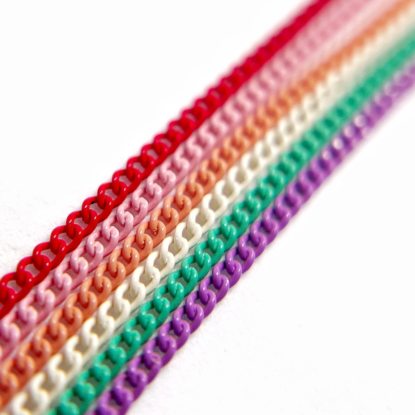 Close-Up of Multi-Color Nail Art Chains in vivid  tones on White Background.