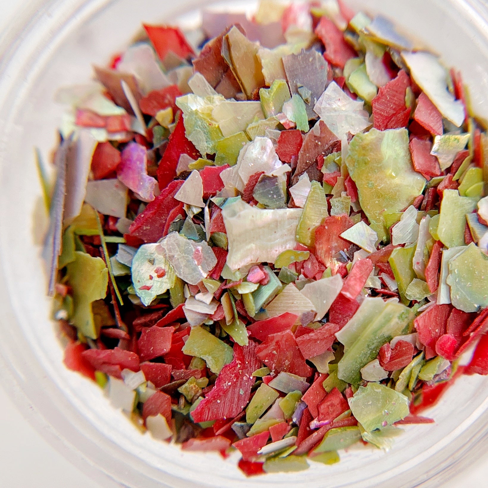 Detail shot of shell mix in clear jar on white background.