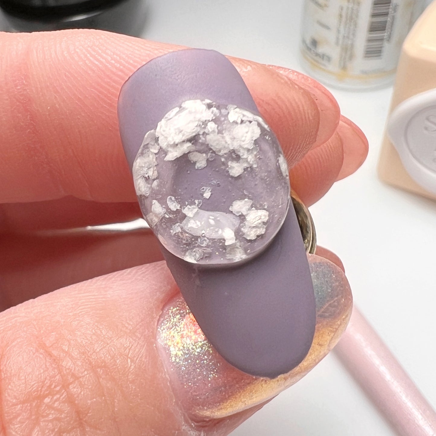 Hand Holding Purple Nail Art Tip with 3D Snow Speckle Encapsulation