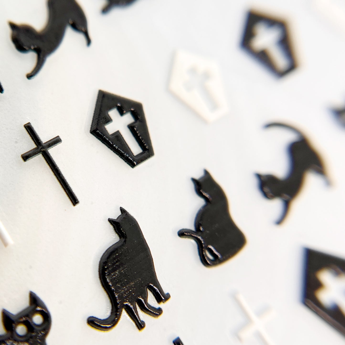 Cats & Coffins Nail Stickers - Embossed Black and White Nail Stickers with Cat, Casket, and Cross Designs, Displayed on White Background.