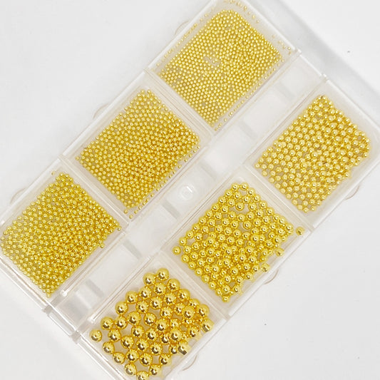 Gold Metal Balls (Caviar) for Nail Art - Aerial View on White Background.