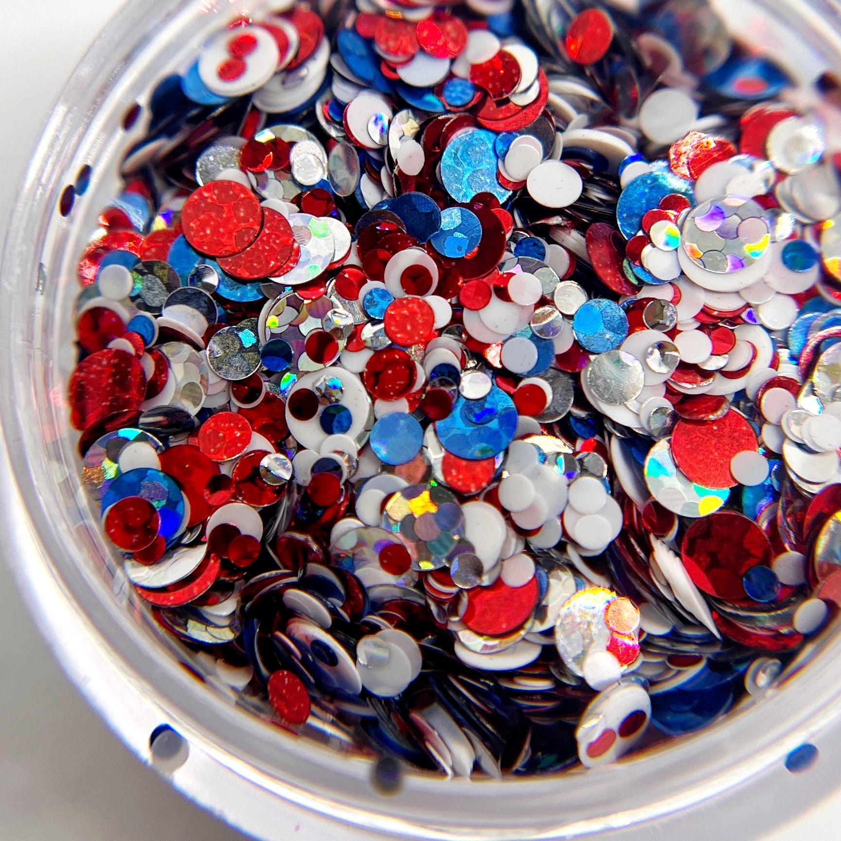 Multicolor circle glitter mix in clear jar on white background. 