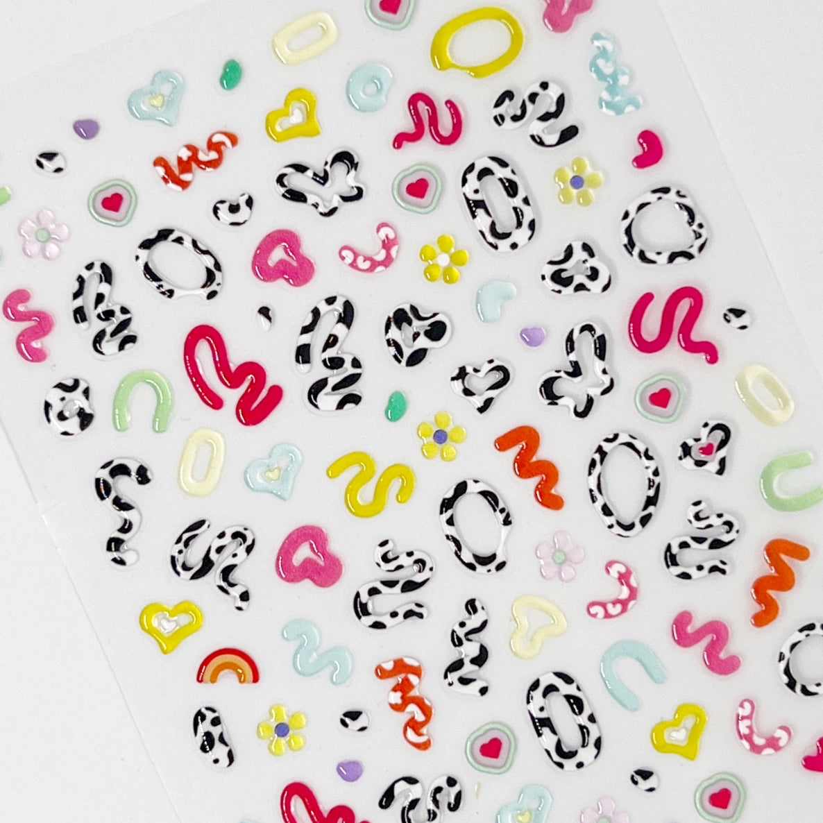 Moo Squiggs Nail Stickers - 3D Jelly-Textured Nail Stickers in Assorted Colors and Cow Print on white background. 