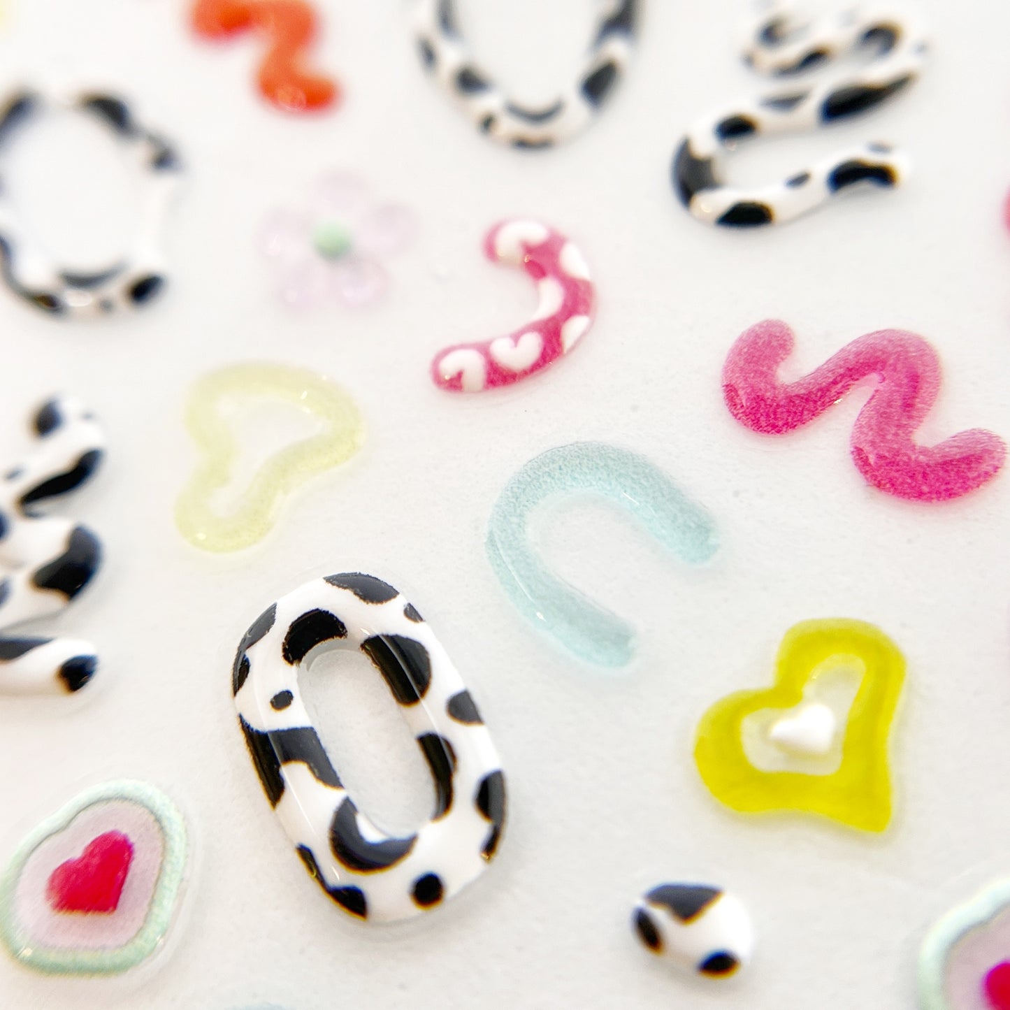 Close-Up of Moo Squiggs Nail Stickers - Detailed View of 3D Jelly-Textured Nail Stickers in Various Colors and Cow Print.