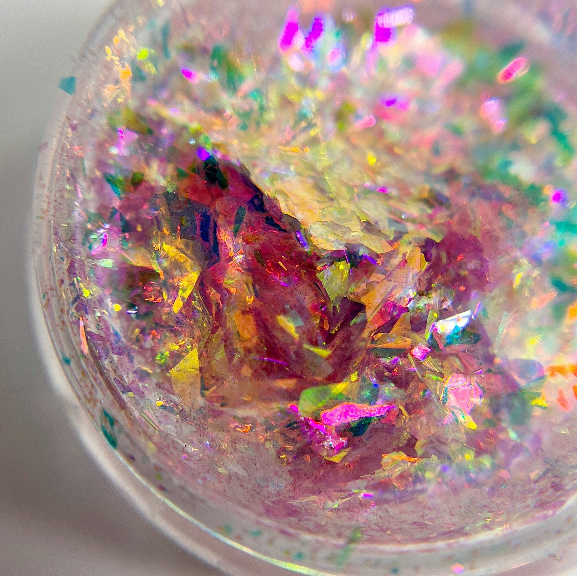 Multicolor flakes in clear jar on white background. 