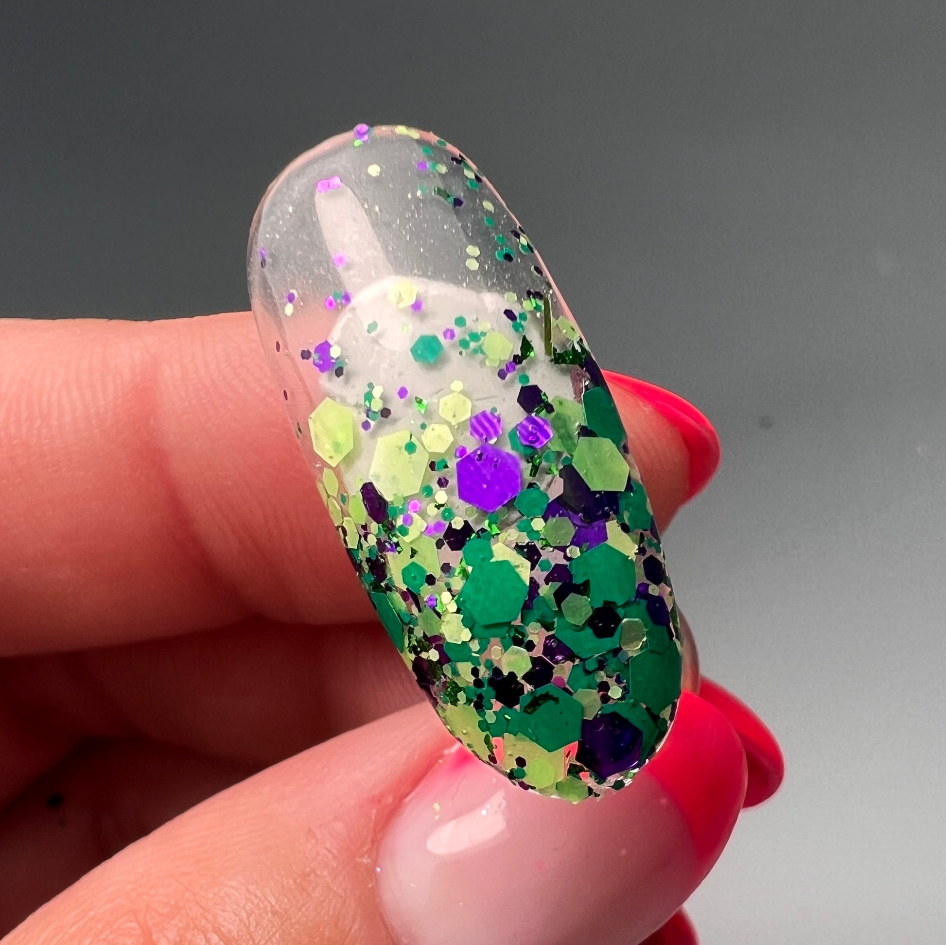 Hand holding decorated nail tip.