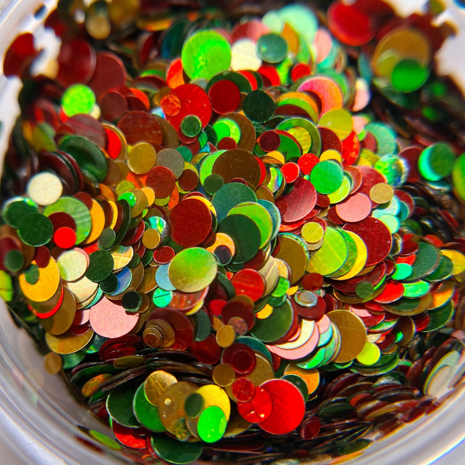 Multicolor circle glitter in clear jar on white background.