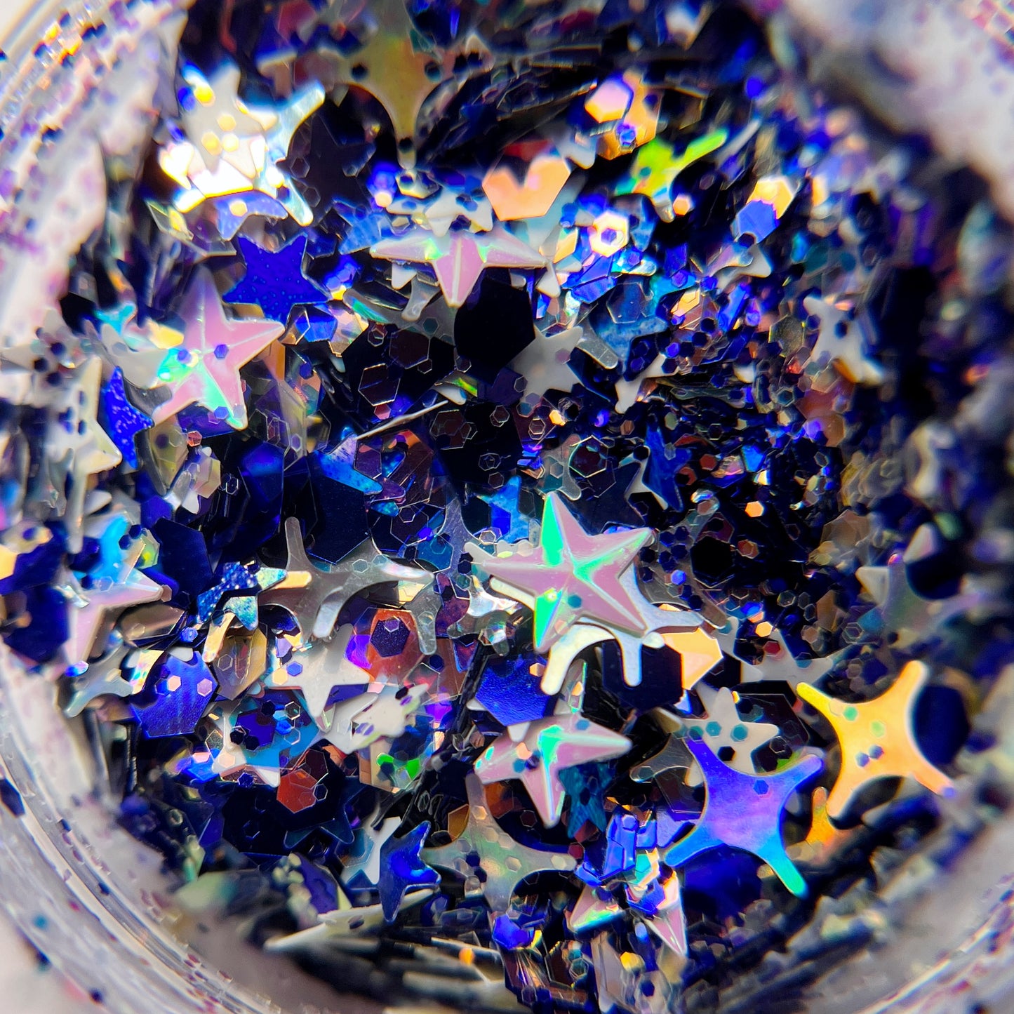 Mixed color and shape glitter mix in clear jar. 