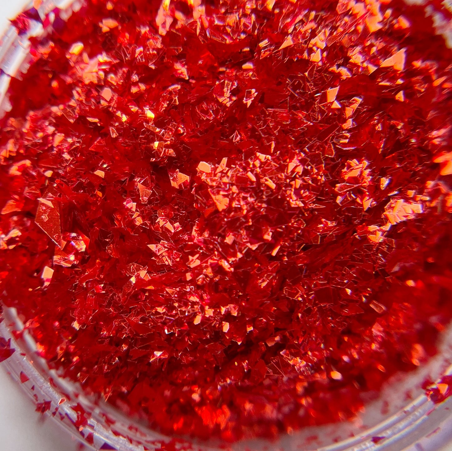 Detailed view of red irregular shaped glitter. 