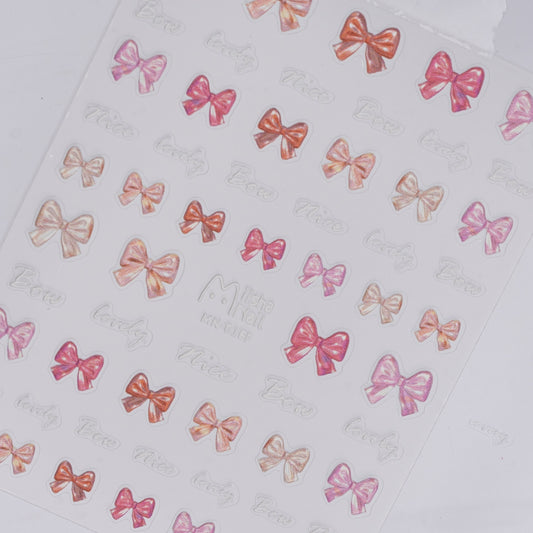 Photo of pink bow nail stickers with raised texture on white background.