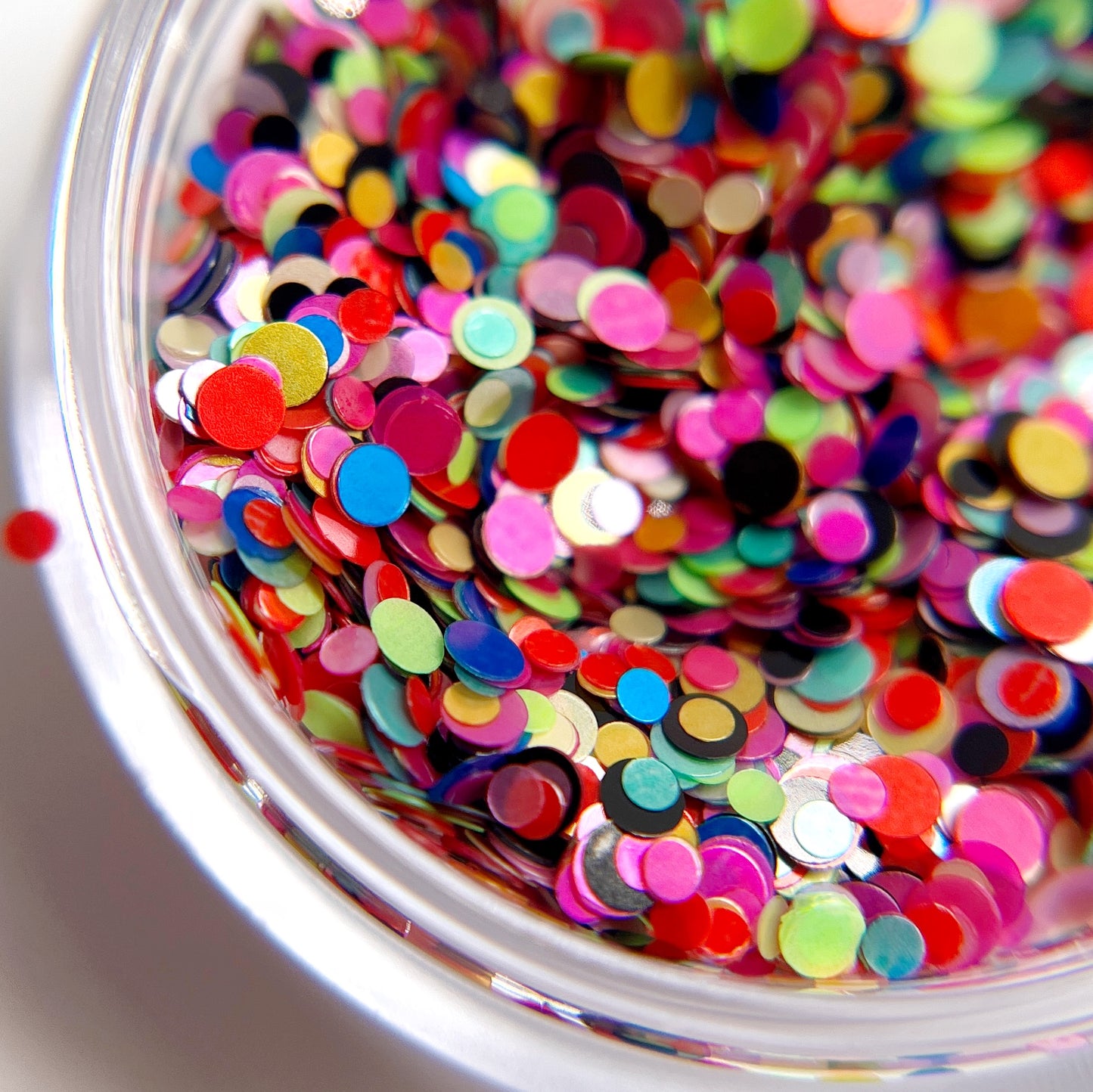 multicolor dot glitter in clear jar on white baclground. 