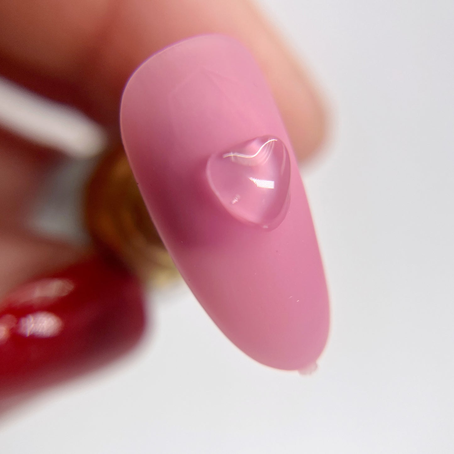 Detail view of pink nail tips with clear heart charms