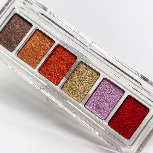 Metallic pigment palette in clear case on white background.