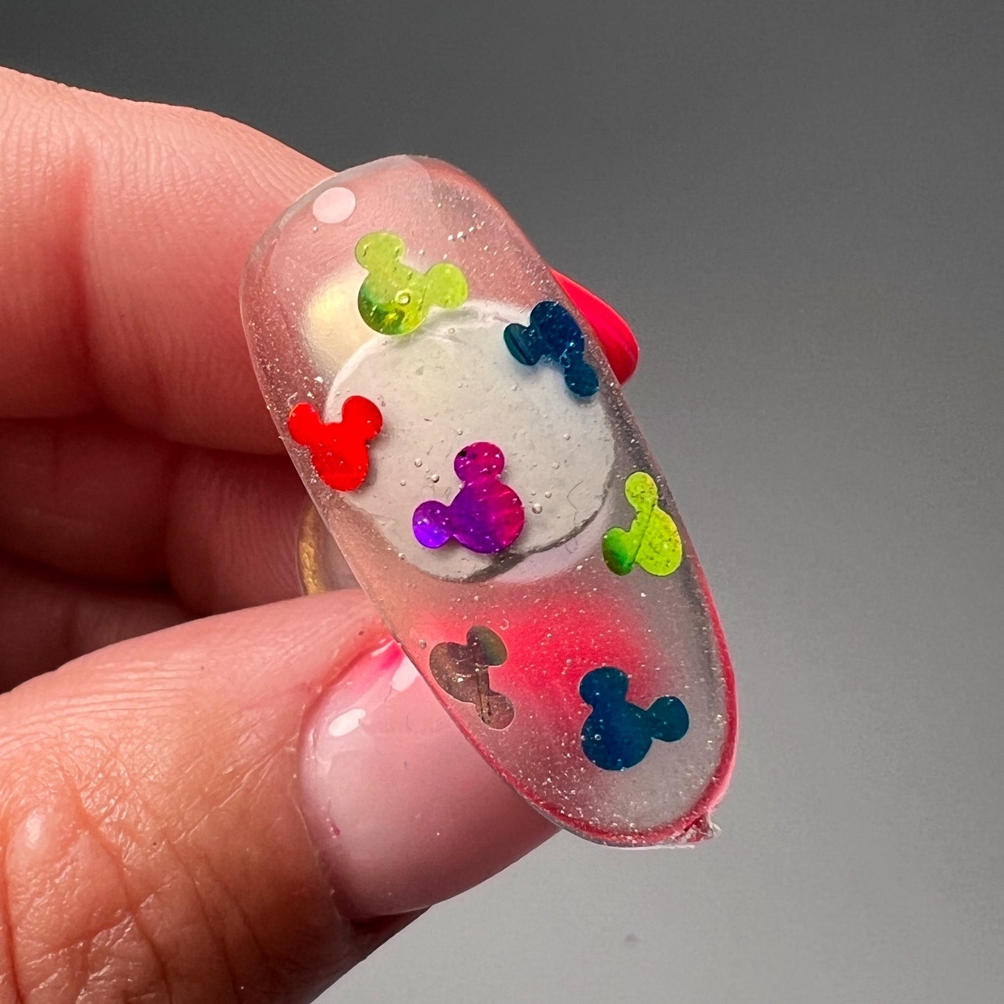 Hand holding decorated nail tip. 