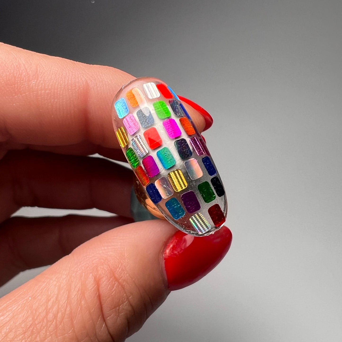 Hand holding decorated  nail tip. 