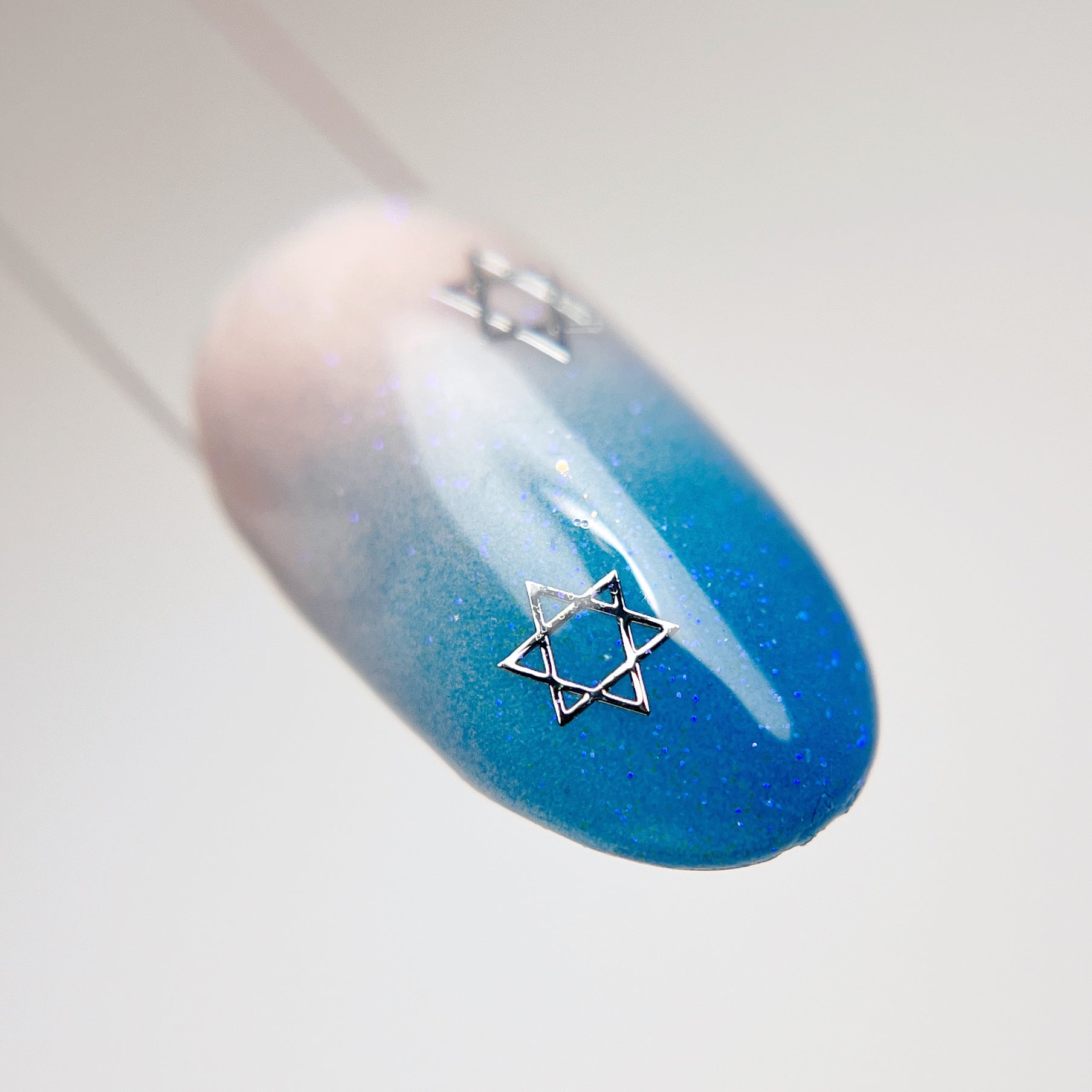 Nail art tips with blue ombre and star detail. 