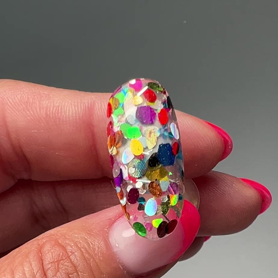 Video of hand holding decorated nail tip. 