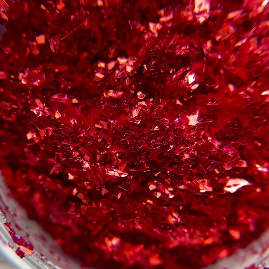 Video of Detailed view of red irregular shaped glitter. 