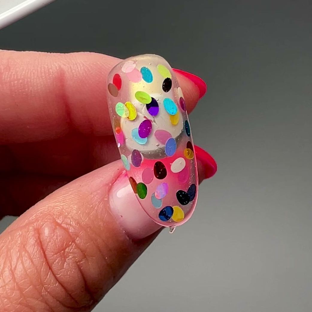 Video of hand holding decorated nail tip. 