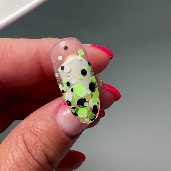 Video of hand holding decorated nail tip. 