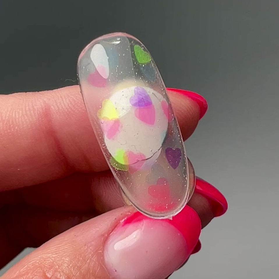 Video of hand holding decorated nail tip.
