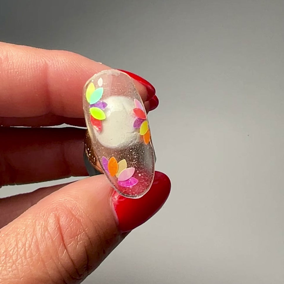 Video of hand holding decorated nail tip. 