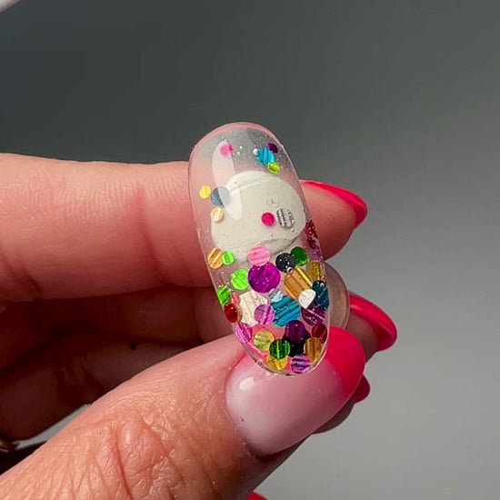 Video of hand holding decorated nail tip. 