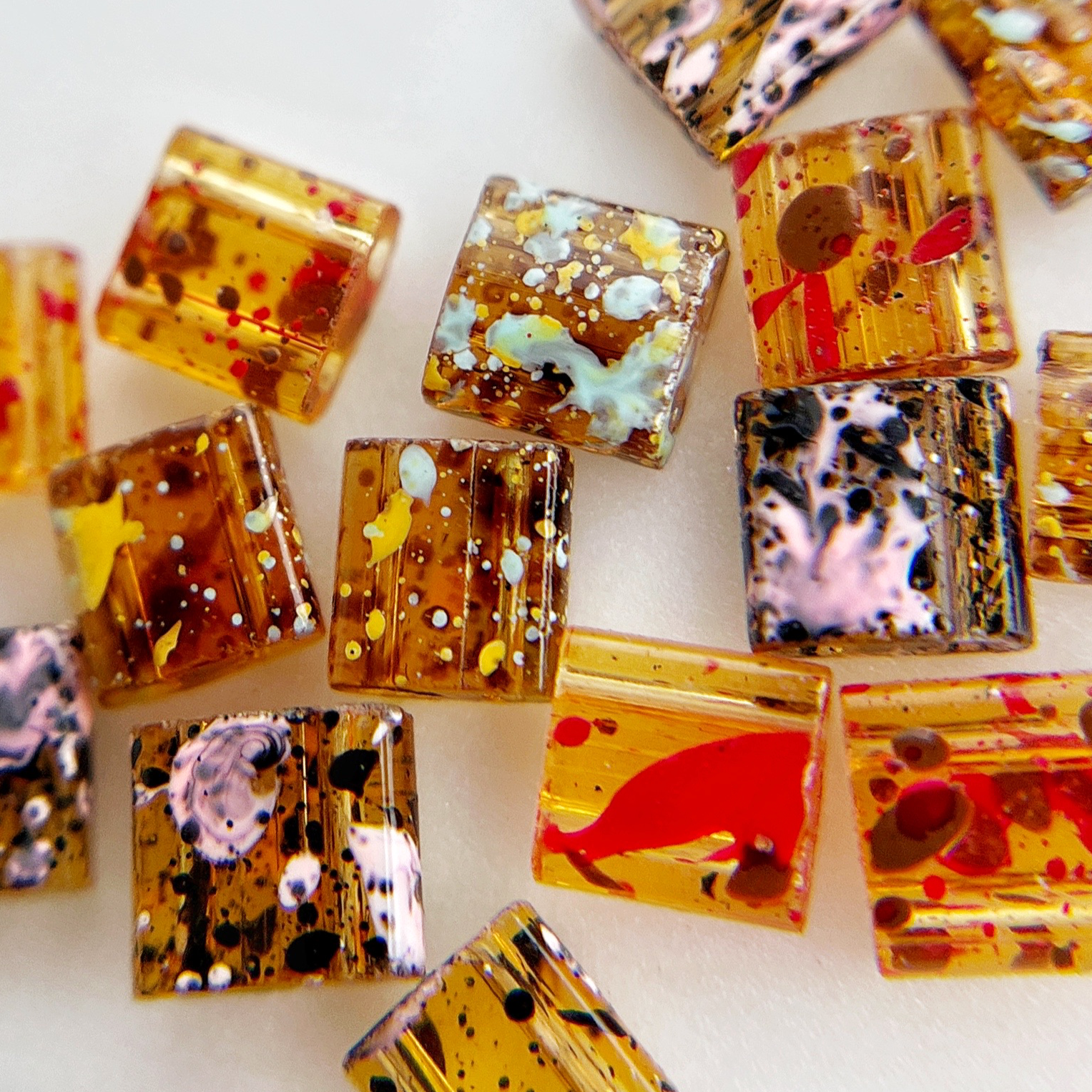 Multicolor square resin nail charms on white background. 