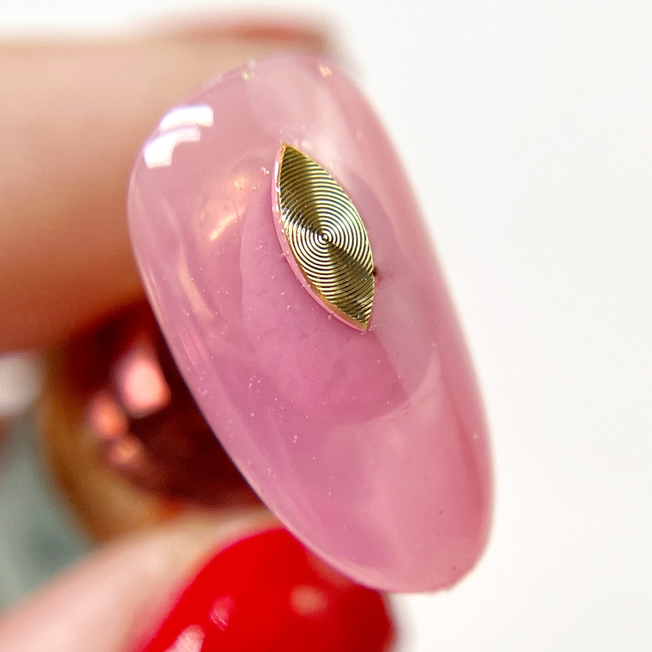 Hand holding decorated nail tip.