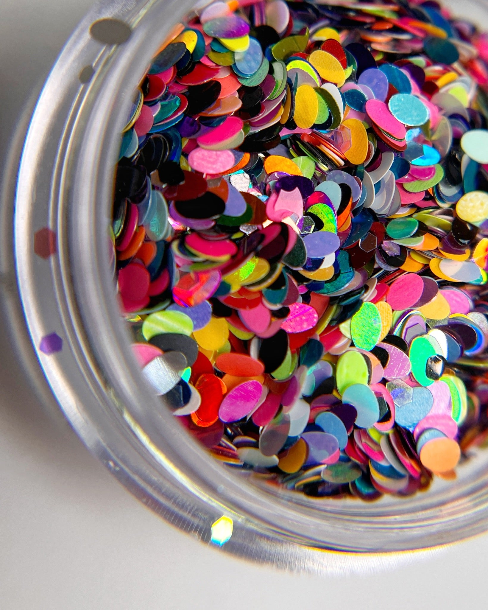 Glitter mix in clear jar on white background. 